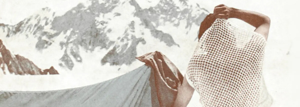 A person in a white mesh base layer top against a snowy mountain backdrop.